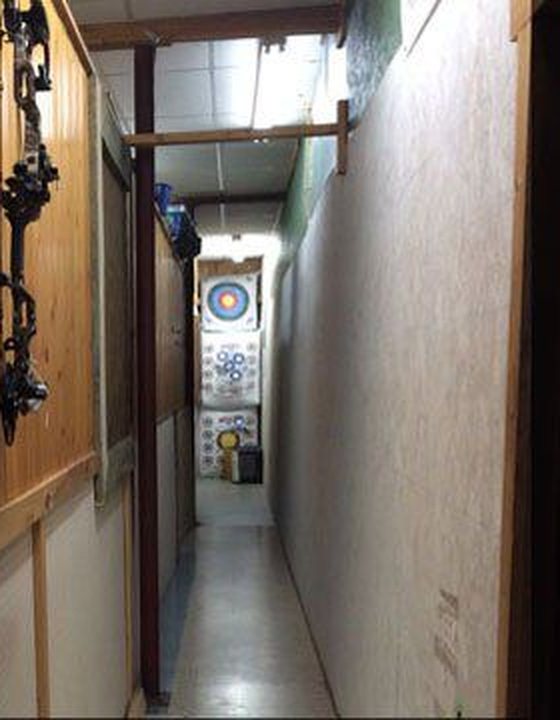 Indoor video archery range lane where customers shoot bows before buying